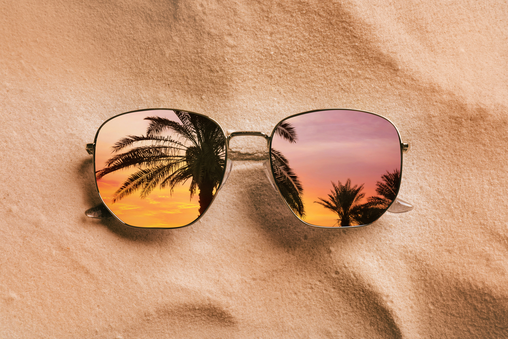 palms,at,beautiful,sunset,mirroring,in,sunglasses,on,sandy,beach,